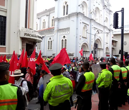 Protestors march on Simon Bolivar as police guard the mayor's office,