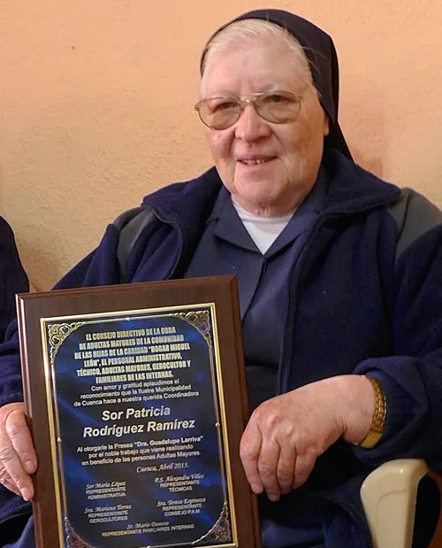 r (Sister) Patricia of the Hermanitas de la Caridad (Sisters of Charity) with the plaque she was awarded for service to the community.