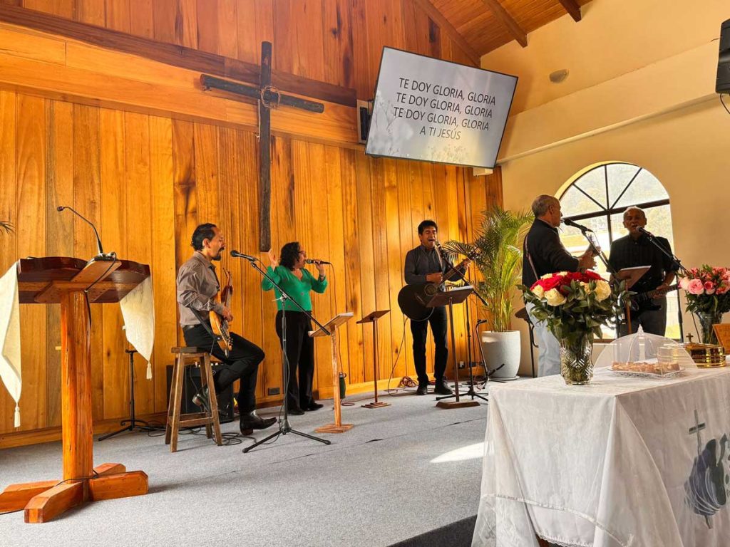 Students and professors engaging in an advanced theological discussion during an evening class at the Seminario Bíblico Evangélico de Cuenca (SEMBEC).
