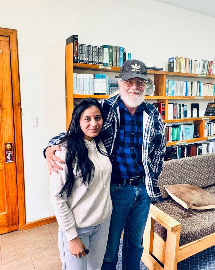 Brian and Diana, an expat couple living in Paccha, posing together smiling in the library of HopeSeed School where they volunteer.